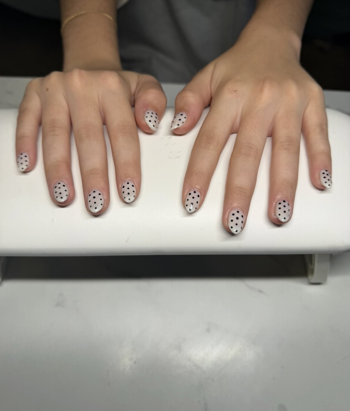 Nude structured gel nails with black polka dots by Raegan